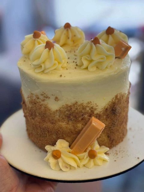 Caramel cake with piped cream and caramel candy pieces