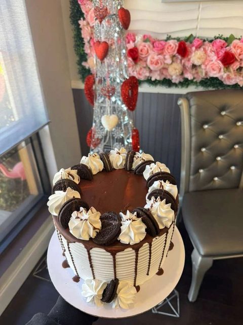 Chocolate drip cake decorated with macarons and cream