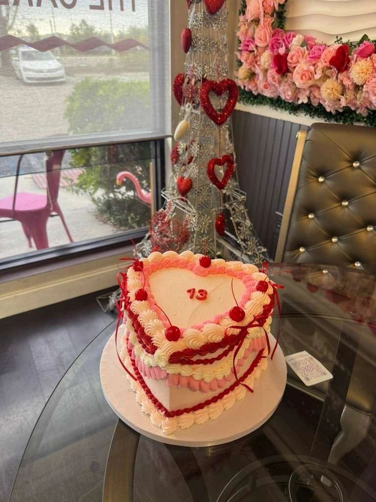 Pink heart-shaped cake piped with red trim