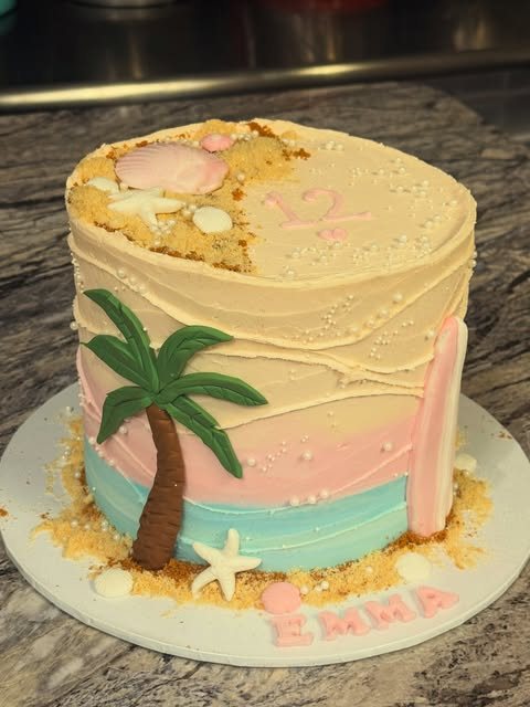 Beach-themed birthday cake with a palm tree and surfboard