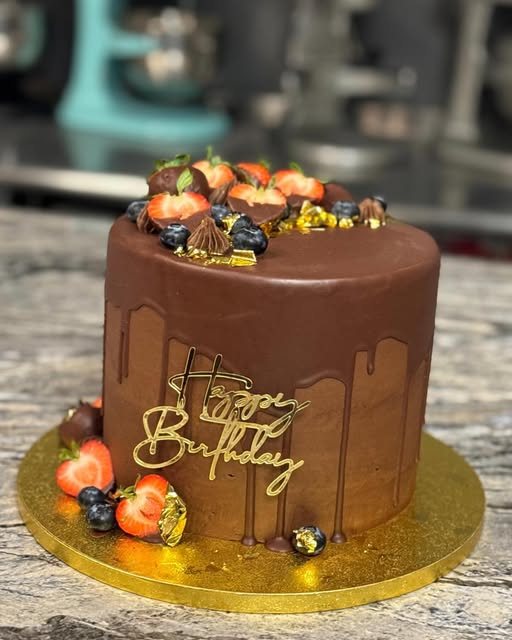 Chocolate drip cake topped with strawberries and figs
